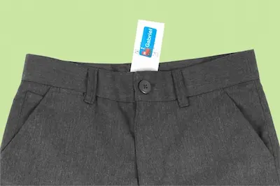Grijze broek met een gepersonaliseerd naamlabel op het waslabel